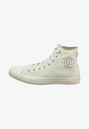Basket montante en toile blanc cassé avec lacets blancs, semelle en caoutchouc et emblème circulaire représentant un globe sur la partie extérieure de la cheville.
