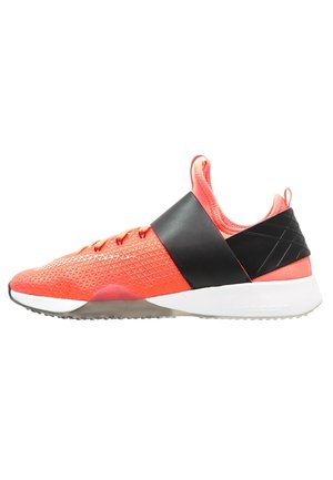 Basket en maille rouge avec une sangle noire au milieu du pied, semelle blanche et texture géométrique sur la tige. Conçue pour une utilisation athlétique.