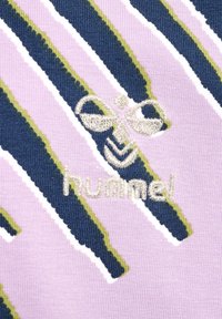 Lilla stof med diagonale striber i marineblå og grøn, med hvide kantlinjer. Broderet "hummel" logo i beige nederst.