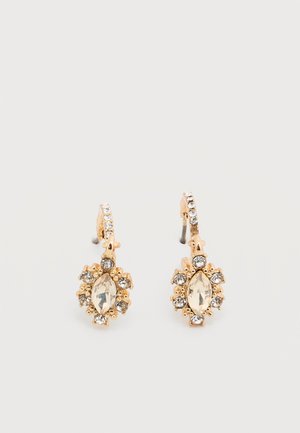 Orecchini pendenti in tonalità oro con pietre centrali marquise trasparenti circondate da piccoli cristalli rotondi trasparenti su ganci curvi.