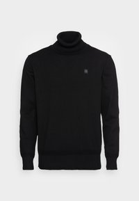 Pull en col roulé noir avec des poignets côtelés, une coupe ajustée et un petit logo carré sur la poitrine. Fabriqué en tissu tricoté doux.