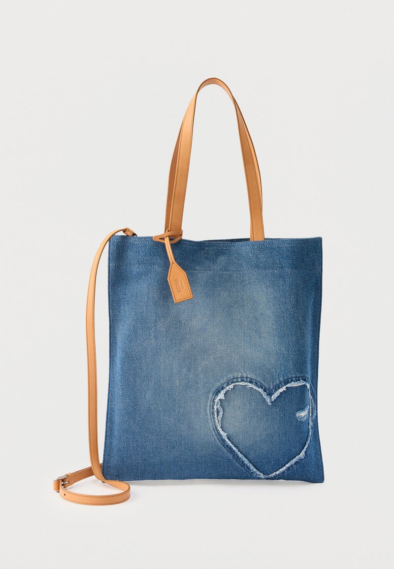 Τσάντα τοτ από γαλάζιο τζιν με ταμπά δερμάτινες λαβές και σχέδιο καρδιάς κεντημένο στην κάτω δεξιά γωνία.