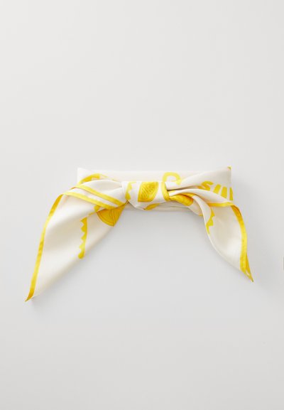 White silk scarf knotted in a bow with yellow lemon designs and accents, featuring smooth texture and contrasting yellow border.