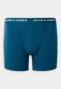 Teal pamučne bokserice s elastičnim pojasom koje sadrže bijeli branding "JACK & JONES". Srednji kroj s oblikovanim džepom i bešavnim otvaranjima za noge.