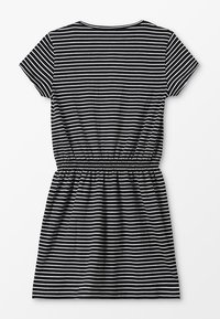 Randig klänning med kort ärm i svart och vitt, med elastisk midja och avslappnad passform. Mjuk tyg med klassisk rund halsringning.