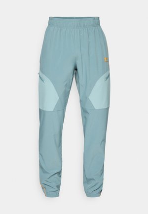 Lichtblauwe sportbroek met een trekkoord in de taille, taps toelopende benen, zijzakken en contrasterende lichterblauwe accenten.