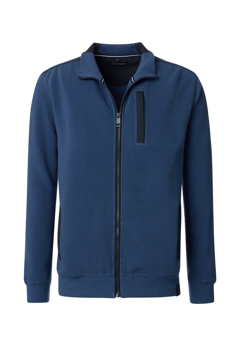 Giacca a zip blu navy in tessuto testurizzato, con colletto alto, tasca sul petto e dettagli neri sulle spalle e ai lati.