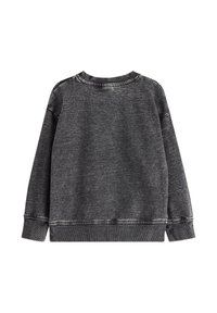 Sweatshirt gris foncé avec une texture douce, col rond et manches longues. Présente des coutures contrastées le long des poignets et de l'ourlet.