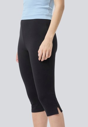 Black cropped leggings with side slits, made from stretchy material. Paired with a light blue ribbed tank top for contrast.