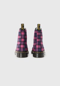 Bottines à carreaux violets avec des accents roses vifs. Caractéristiques des semelles noires, des étiquettes de marque jaunes et une finition texturée. Fabriquées en tissu.