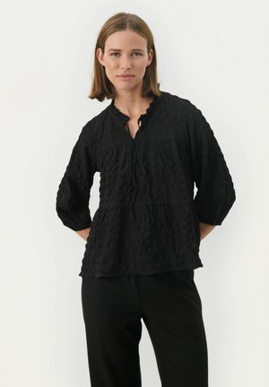 Sort tekstureret bluse med rynket halsudskæring, trekvartærmer og løs pasform, præget af et lagdelt design og let glans.