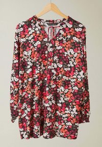 Kukallinen pusero pitkillä hihoilla, jossa on punaisia, vaaleanpunaisia ja valkoisia kukkia tummanruskealla taustalla, pyöreä pääntie ja kokoontuneet hihansuut.