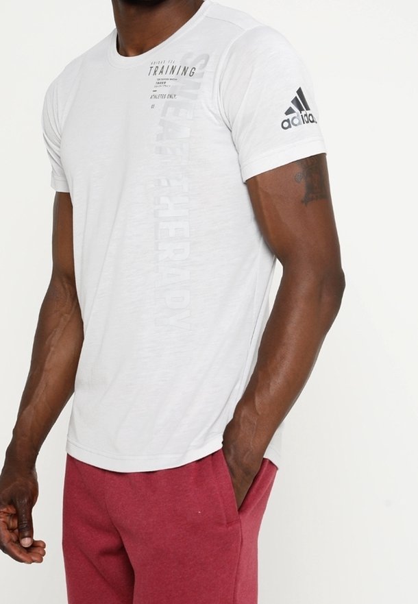 Vit kortärmad sporttröja med rund hals, med svart text och en Adidas-logotyp på vänster ärm. Lättviktig tygstruktur.