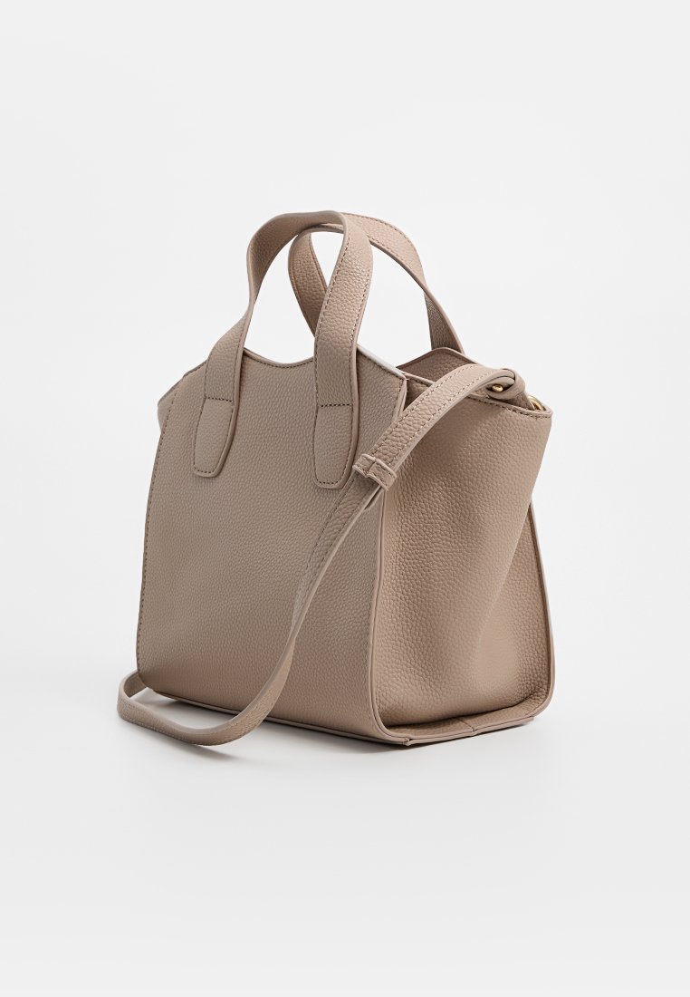 Bolso de mano de cuero beige con acabado texturizado, dos asas y una correa de hombro ajustable. Cuenta con cierre de cremallera y forma estructurada.