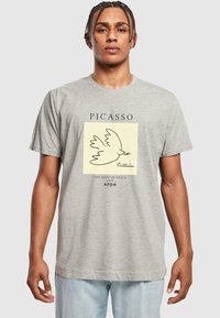 Grå bomulds-T-shirt med en minimalistisk Picasso-illustration af en due, med tekst der siger "FREDENS DUE 1949" og "A.P.O.H.".