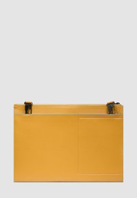 Custodia rettangolare gialla in pelle con una tasca frontale e clip metalliche nere su uno sfondo grigio chiaro.