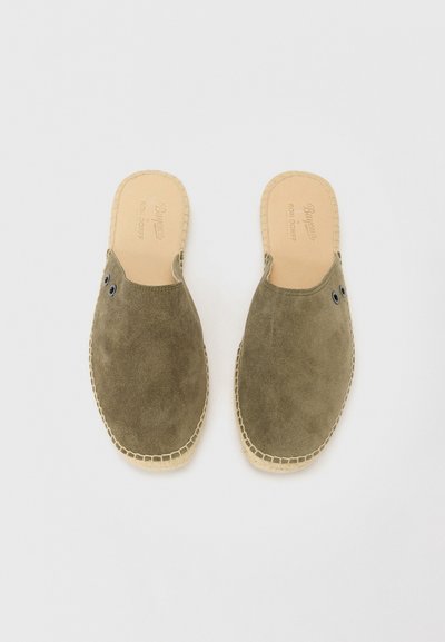 Olíva zöld velúr slip-on cipők kerek orral, barna bőrbelsővel és kontrasztos varrással. Két fekete fűzőlyukkal rendelkezik mindkét oldalon.