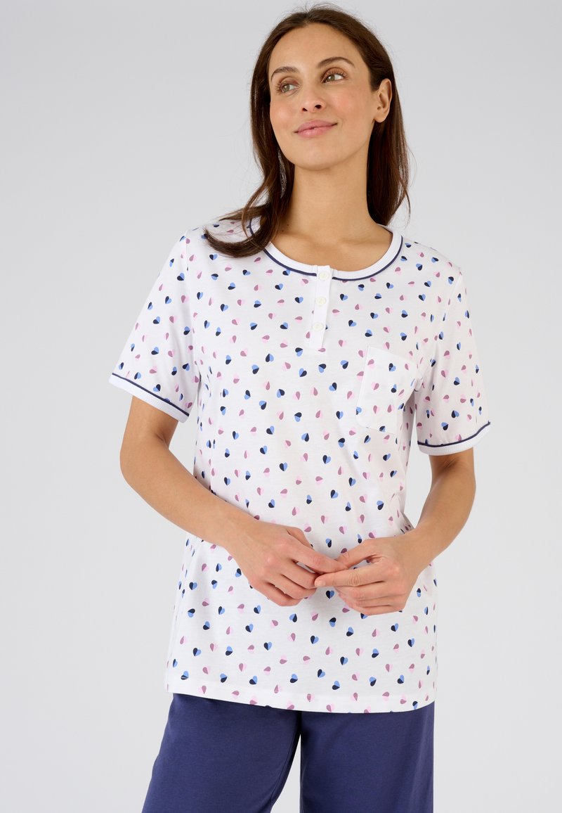 Top de algodón de manga corta con patrones de corazones en rosa, azul y navy, cuello redondo con tapeta de botones y un bolsillo en el pecho.