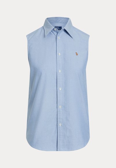 Šviesiai mėlyna medvilninė marškinėlių liemenė be rankovių su sagutėmis. Turi klasikinius apykaklę ir siuvinėtą logotipą ant krūtinės. Lygios tekstūros.