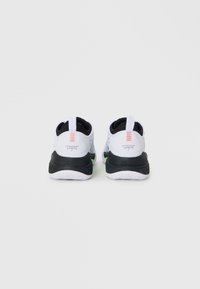 Bijele atletske tenisice s crnim potplatom, s gornjim dijelom od mrežastog materijala, glatke teksture i narančastim detaljima na peti. Vidljiv K-Swiss branding.