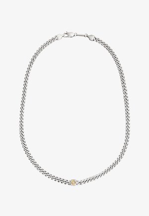 Zilveren metalen ketting met in elkaar grijpende schakels, voorzien van een gestructureerde gouden accent in het midden. Glad oppervlak, eigentijds ontwerp.