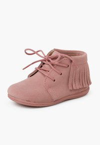 Botín de ante rosa hasta el tobillo con detalle de flecos, punta redonda y cierre de cordones. Superficie texturizada y forro suave para mayor comodidad.
