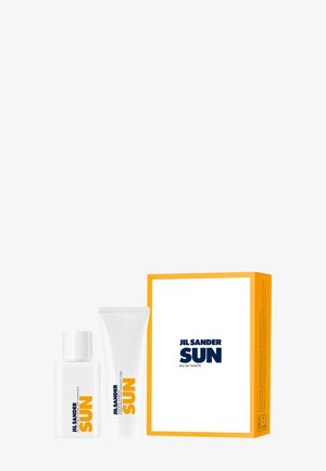 Set de parfum JIL SANDER SUN, comprenant un flacon transparent et un tube blanc. L'emballage est blanc avec un accent jaune vif et un texte bleu en gras.