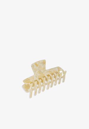 Clips per capelli di colore crema realizzati in plastica resistente, con un motivo marmorizzato, otto denti di presa e un design superiore arrotondato.