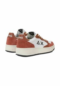 Sneaker in suede bianco e ruggine con una suola spessa color crema, caratterizzato da un logo nero sul tallone e da un design geometrico sul lato.