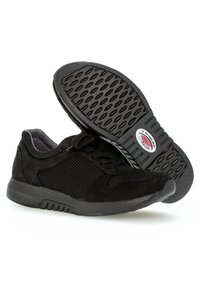 Black sneakers featuring a mesh upper and suede accents, textured rubber sole with a patterned grip, and flat laces.