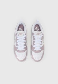 Nike sneakers with a white and light pink color scheme, featuring a mesh upper, perforated toe, and white laces. Accented logo on tongue.