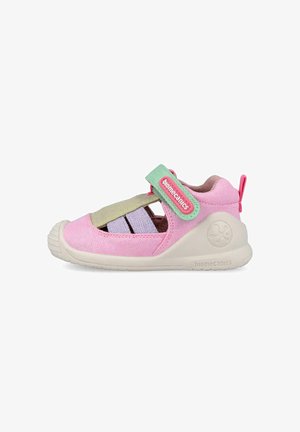 Sandalo chiuso rosa per bambini con suola beige, cinturino in velcro verde e rosa, e sezioni di tessuto ritagliate per la traspirabilità.