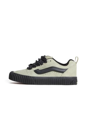 Niskie sneakersy z jasnoszarego zamszu z czarną gumową podeszwą, czarnym falistym detalem z boku, czarnymi sznurówkami i pętelką z tyłu.
