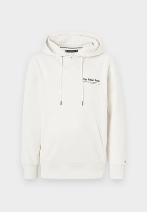 Fehér kapucnis pulóver, pamutból készült, elülső zsebbel, húzózsinórral ellátott kapucnival és zöld szöveggel: "A Villiger Híradó". Bordás mandzsettákkal és alsó részel.