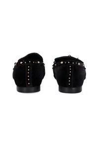 Mocasines de terciopelo negro con acentos de tachuelas a lo largo de los bordes, un acabado suave y una suela de perfil bajo con tachuelas redondas en la parte trasera.