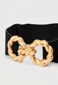 Ceinture élastique noire dotée d'une grande boucle en métal doré entrelacée avec un design torsadé, offrant un accent audacieux et un maintien sécurisé.