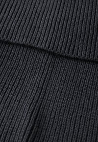 Tessuto a maglia rigata di colore grigio scuro, caratterizzato da linee verticali, una consistenza morbida e un motivo uniforme, adatto per capi di abbigliamento o accessori.