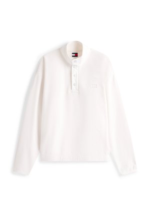 Valge pika varrukaga pullover-särk, pehme tekstuuriga, millel on krae koos nööpidega ning väike logo detail rinnal.