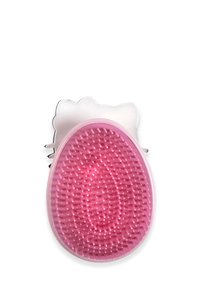 Brosse ovale rose avec des poils en caoutchouc, poignée en forme de chat blanche, surface texturée et bords arrondis pour une prise en main ergonomique.
