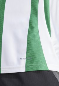 Grünes und weißes Sporttrikot mit einem strukturierten Muster und dem „AEROREADY“-Logo am Saum. Der Stoff wirkt leicht und atmungsaktiv.