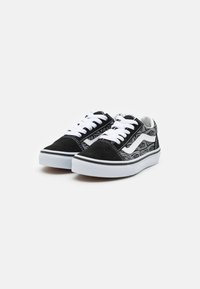 Zapatillas de lona negras con cordones blancos y una franja blanca elevada. Presenta paneles laterales texturizados con un patrón repetido del logotipo de la marca.