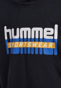 Schwarzer Sweatshirt mit "hummel" in Weiß und "SPORTSWEAR" in Gelb, mit blauen perforierten Akzenten unter dem Text.