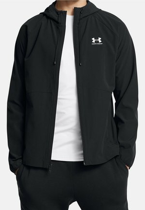 Leichte schwarze Kapuzenjacke mit Reißverschluss, Logo auf der Brust und Seitentaschen. Glatte Textur und figurbetontes Design für Komfort.