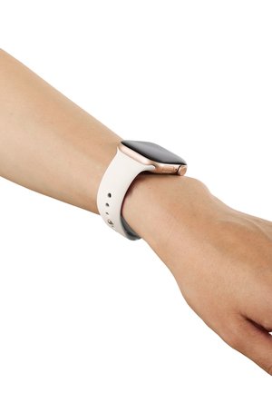 Smartwatch med sort skærm og hvid rem båret på en persons venstre håndled mod en hvid baggrund.