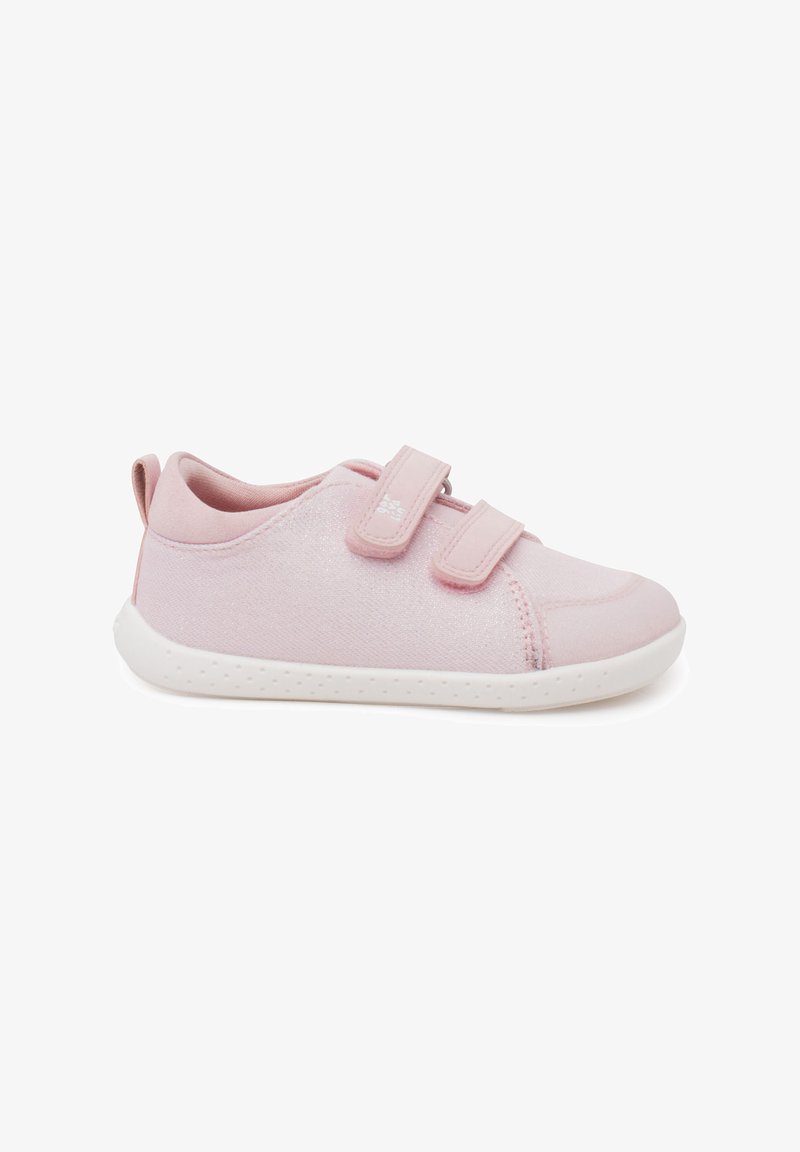 Zapatilla de tela en color rosa claro con dos tiras de velcro, puntera redondeada, suela de goma blanca en contraste y un sutil brillo en el material.