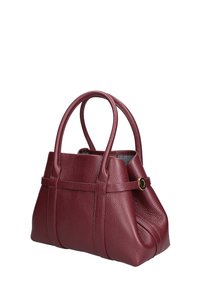Borsa a mano in pelle martellata color bordeaux con due manici arrotondati. Presenta una chiusura con zip, pieghe laterali e un dettaglio decorativo in tono oro.