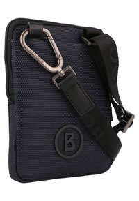 Textured navy blue shoulder bag with a black logo, adjustable strap, and metallic carabiner. Zipper closure, compact design.