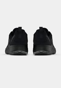 Schwarze Sportschuhe mit strukturiertem Obermaterial, verstärkter Ferse und Gummisohle. Mit Laschen zum einfachen An- und Ausziehen sowie einem minimalistischen Design.