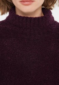 Lila Fleece-Turtleneck mit ribbeliger, strukturierter Oberfläche, hoher Kragen und weichem, plüschigem Stofffinish.