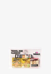 Set de cosmétiques de voyage dans une pochette transparente ; contient quatre boîtes carrées avec des designs rétro colorés et des étiquettes imprimées.